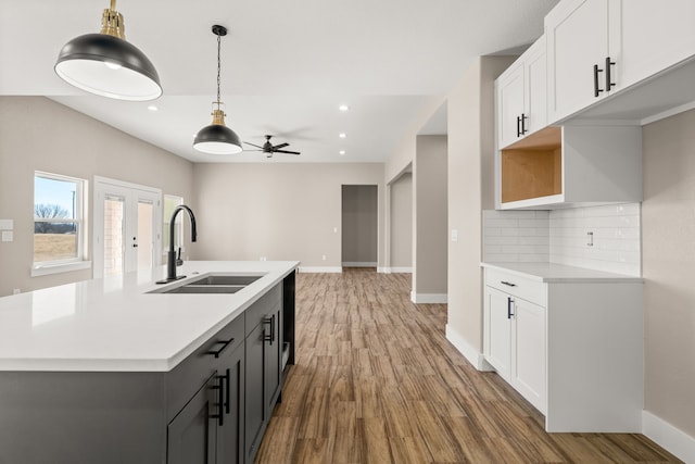 kitchen with white cabinetry, gray cabinets, sink, and hanging light fixtures