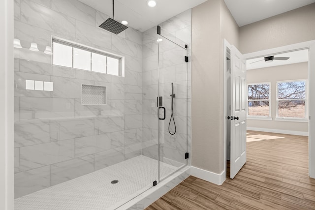 bathroom featuring hardwood / wood-style flooring, ceiling fan, and walk in shower