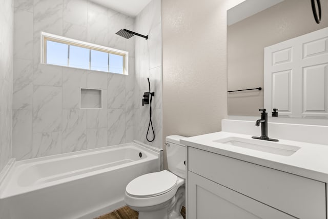 full bathroom featuring tiled shower / bath, vanity, and toilet