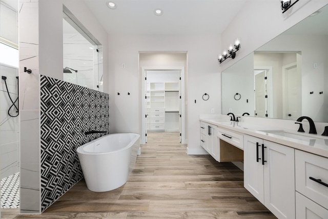 bathroom with vanity, hardwood / wood-style flooring, and plus walk in shower