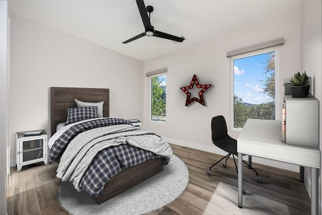 104 Cactus Cor, Horseshoe Bay, TX 78657 - bedroom with a desk, wood finished floors, baseboards, and a ceiling fan