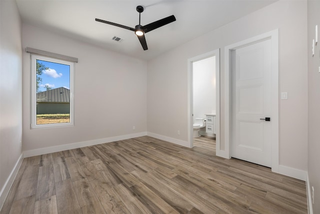 unfurnished bedroom featuring light wood-type flooring, ceiling fan, and ensuite bath