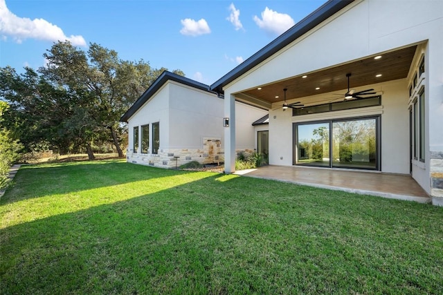 104 Cactus Cor, Horseshoe Bay, TX 78657 - back of house with a ceiling fan, a patio area, stucco siding, a yard, and stone siding