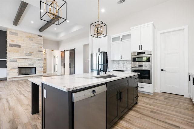 104 Cactus Cor, Horseshoe Bay, TX 78657 - kitchen featuring stainless steel appliances, a sink, a chandelier, white cabinets, and a center island with sink