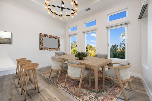 dining space with hardwood / wood-style flooring and a chandelier