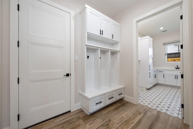 mudroom featuring sink and light wood-type flooring