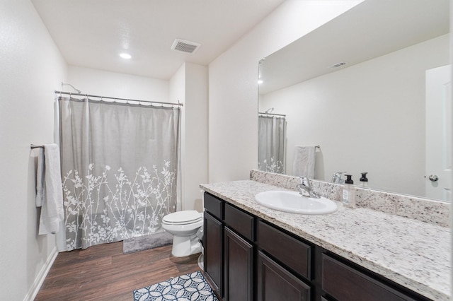 bathroom featuring vanity, toilet, and hardwood / wood-style floors