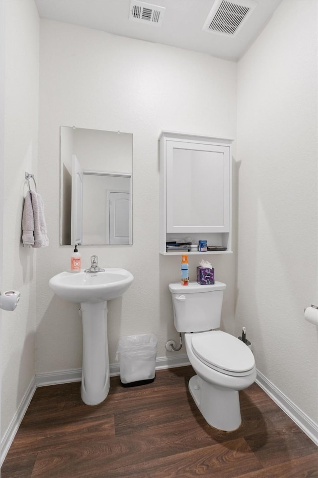 bathroom featuring wood-type flooring and toilet