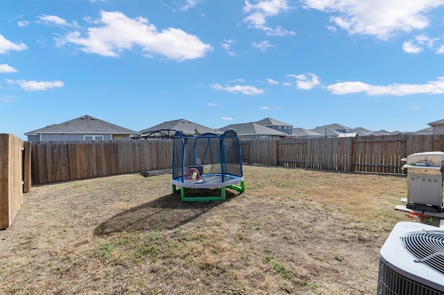 view of yard with a trampoline and cooling unit