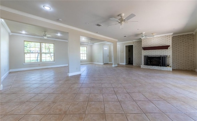 unfurnished living room with a brick fireplace, ornamental molding, ceiling fan, and light tile patterned flooring