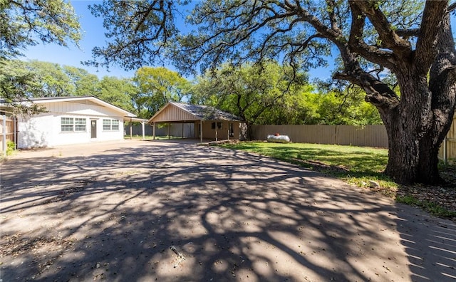 exterior space with a carport and a front lawn