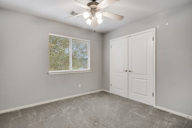 unfurnished bedroom with a closet, visible vents, a ceiling fan, carpet flooring, and baseboards