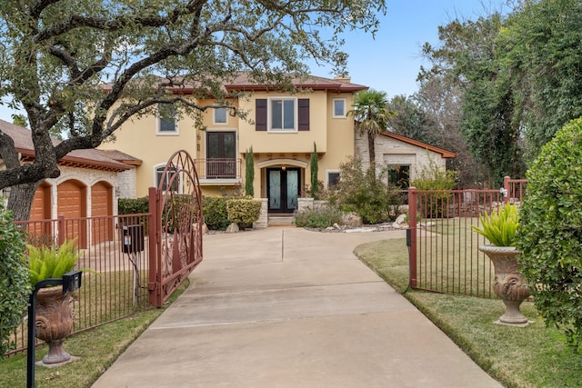 mediterranean / spanish house featuring a garage, a front lawn, and french doors