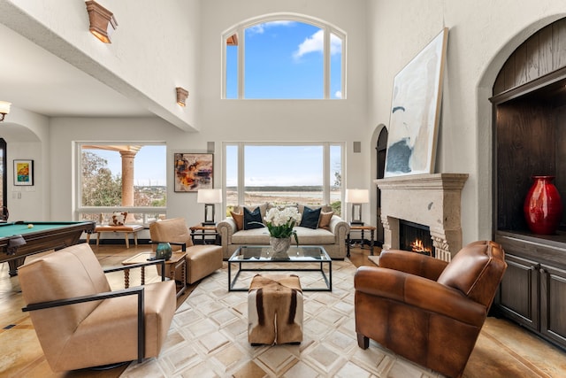 living room with pool table, plenty of natural light, and a towering ceiling