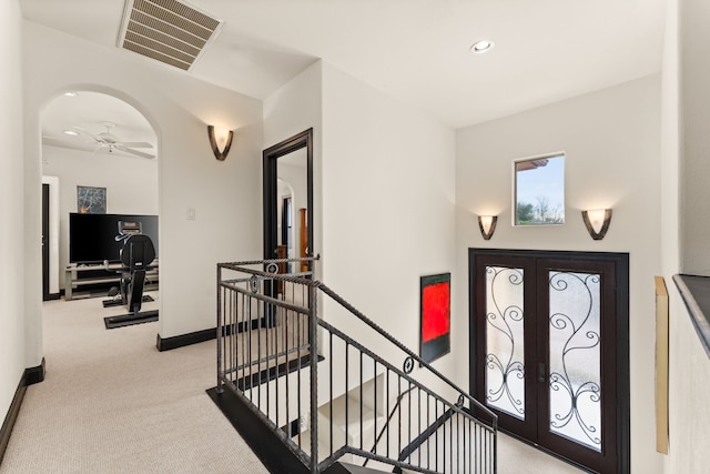 carpeted entrance foyer featuring french doors