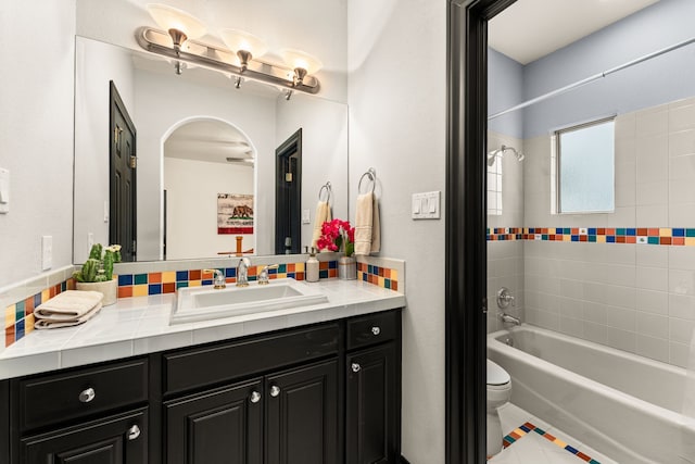 full bathroom featuring vanity, tile patterned flooring, tiled shower / bath combo, and toilet