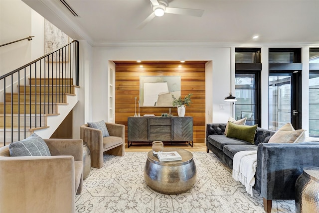 living room with ornamental molding and ceiling fan