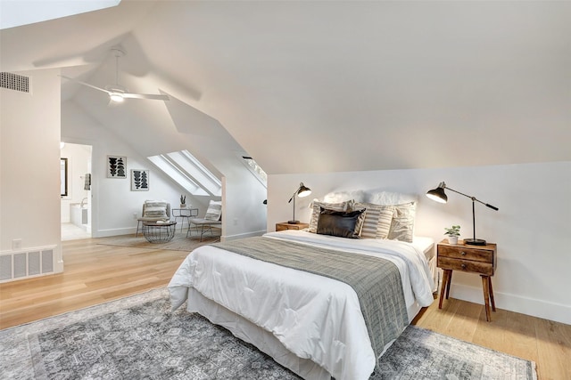 bedroom with lofted ceiling, ensuite bath, wood-type flooring, and ceiling fan