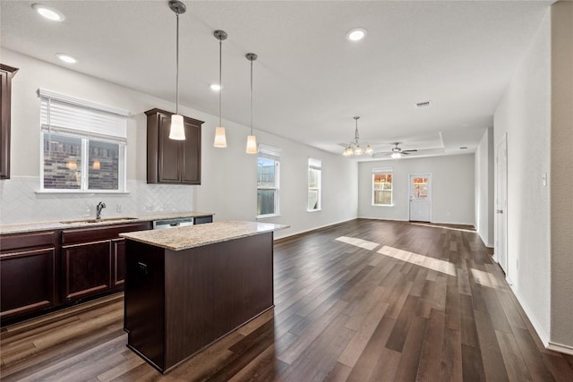 118 Grace Lilly Dr, Buda, TX 78610 - kitchen featuring tasteful backsplash, a center island, open floor plan, dark brown cabinetry, and recessed lighting