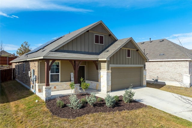 view of front facade featuring a garage, a front lawn, covered porch, and solar panels