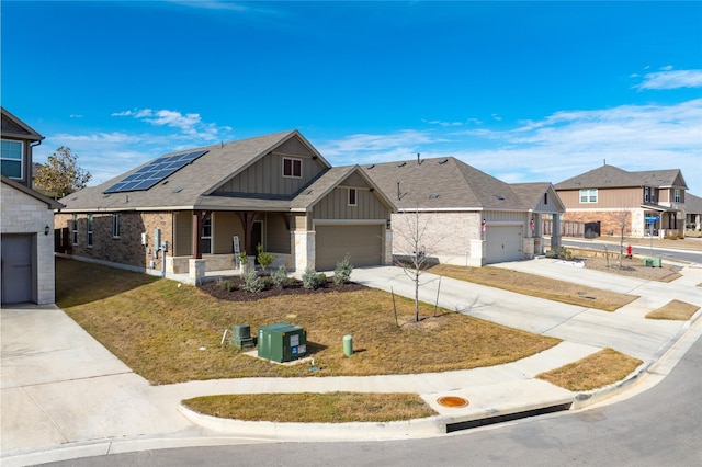 view of front of property featuring a front yard, covered porch, and solar panels