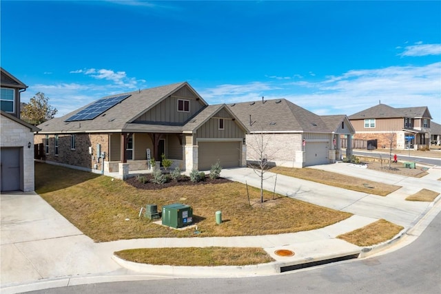 118 Grace Lilly Dr, Buda, TX 78610 - view of front of house with board and batten siding, concrete driveway, a porch, roof mounted solar panels, and a front lawn