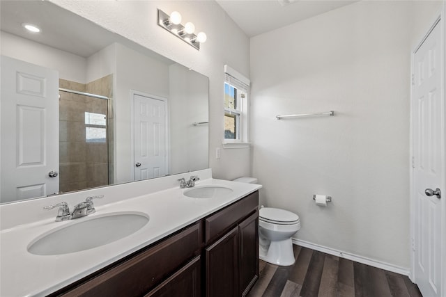 bathroom with wood-type flooring, toilet, an enclosed shower, and vanity