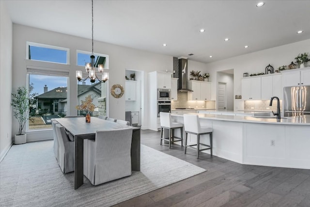 1114 Woodpark Ln, Georgetown, TX 78633 - kitchen featuring stainless steel appliances, wall chimney range hood, a large island, tasteful backsplash, and a chandelier