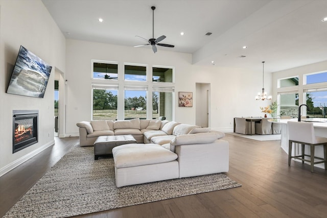 living room featuring sink, dark hardwood / wood-style floors, and ceiling fan with notable chandelier