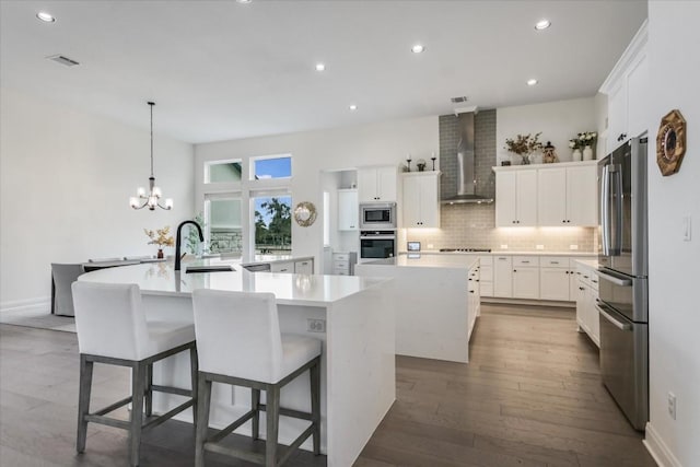 1114 Woodpark Ln, Georgetown, TX 78633 - kitchen with wall chimney exhaust hood, stainless steel appliances, a large island with sink, dark wood finished floors, and recessed lighting