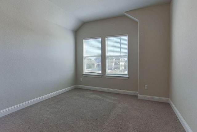 carpeted empty room with lofted ceiling