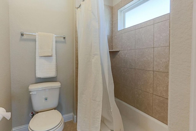 bathroom featuring a shower with shower curtain and toilet