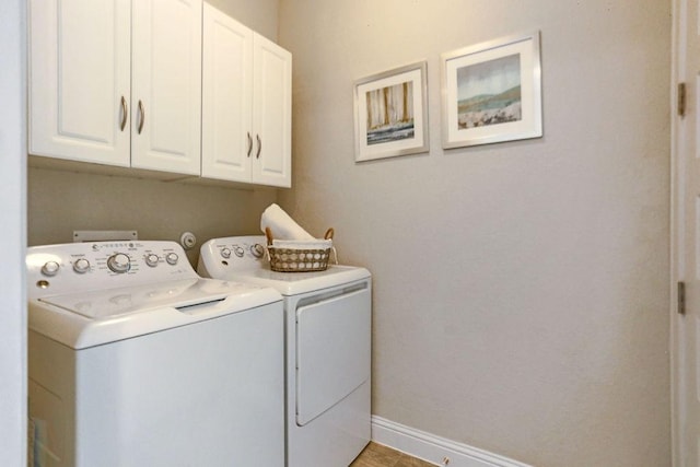 washroom with cabinets and washer and dryer