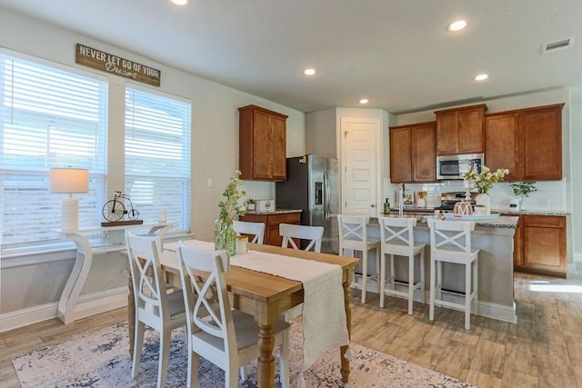 dining area featuring sink and light hardwood / wood-style floors