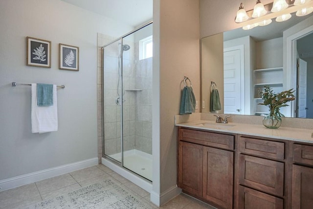 bathroom featuring tile patterned floors, a shower with door, and vanity