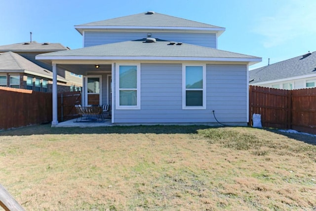 back of property with a yard and a patio area