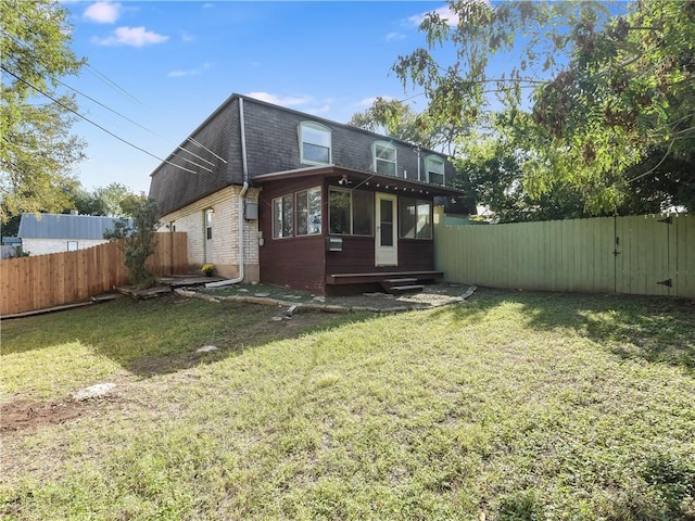 rear view of house with a yard