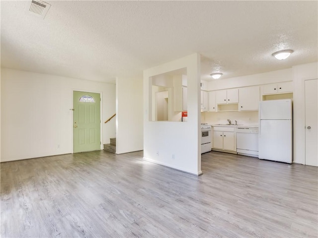 kitchen featuring white cabinetry, a textured ceiling, white appliances, and light hardwood / wood-style floors