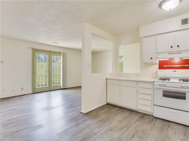 kitchen with french doors, white gas stove, white cabinetry, a textured ceiling, and light hardwood / wood-style flooring