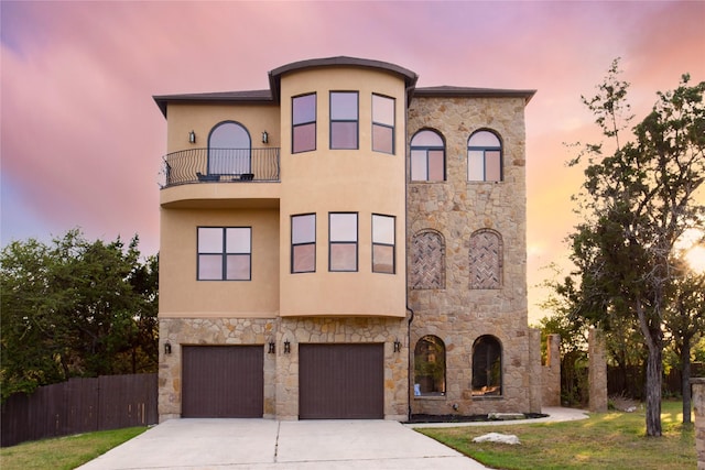 view of front facade featuring a garage, a lawn, and a balcony