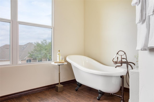 bathroom featuring hardwood / wood-style flooring and a tub to relax in