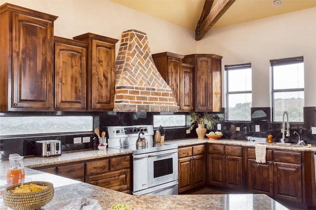 kitchen featuring double oven range, sink, light stone counters, and decorative backsplash