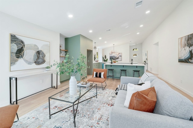 living room with light hardwood / wood-style floors and vaulted ceiling