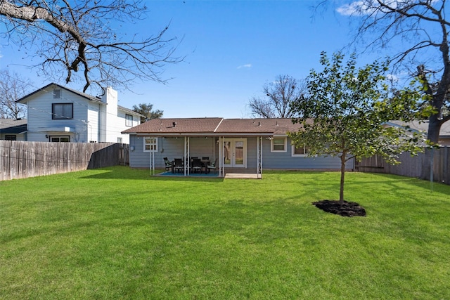 back of property with a yard and a patio area