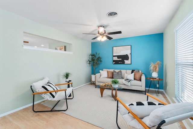 living room with light hardwood / wood-style floors and ceiling fan