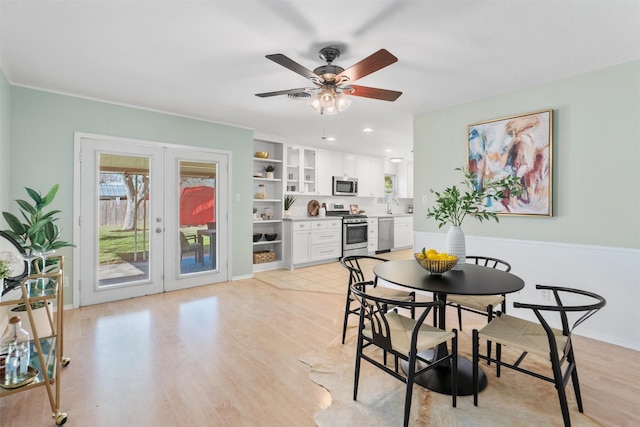 dining room featuring built in features, sink, ceiling fan, light hardwood / wood-style floors, and french doors