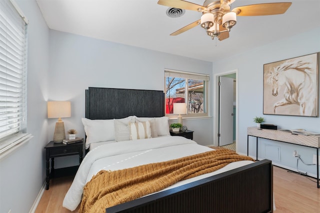 bedroom with multiple windows, ceiling fan, and light hardwood / wood-style flooring