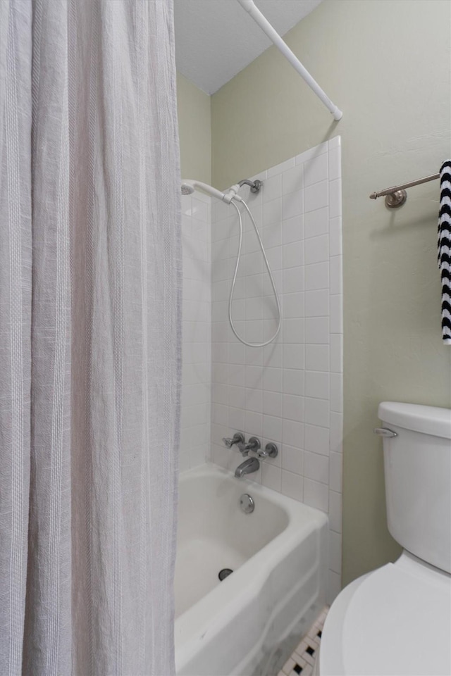 bathroom featuring tile patterned flooring, toilet, and shower / bath combo with shower curtain