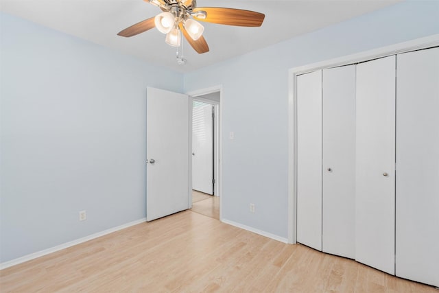 unfurnished bedroom with light wood-type flooring, ceiling fan, and a closet