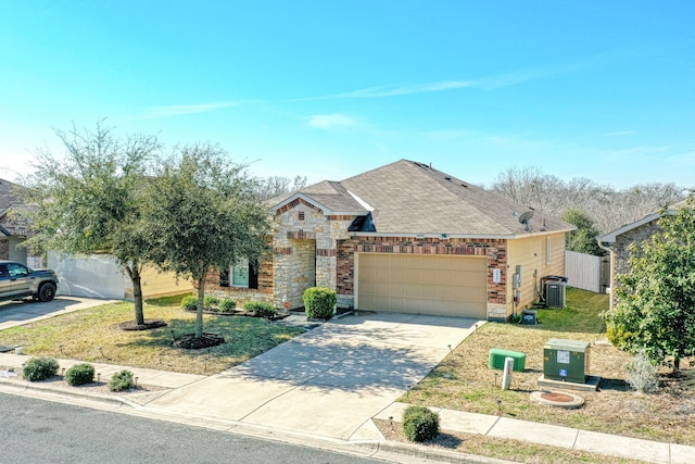 view of front of house with a garage, central AC unit, and a front lawn